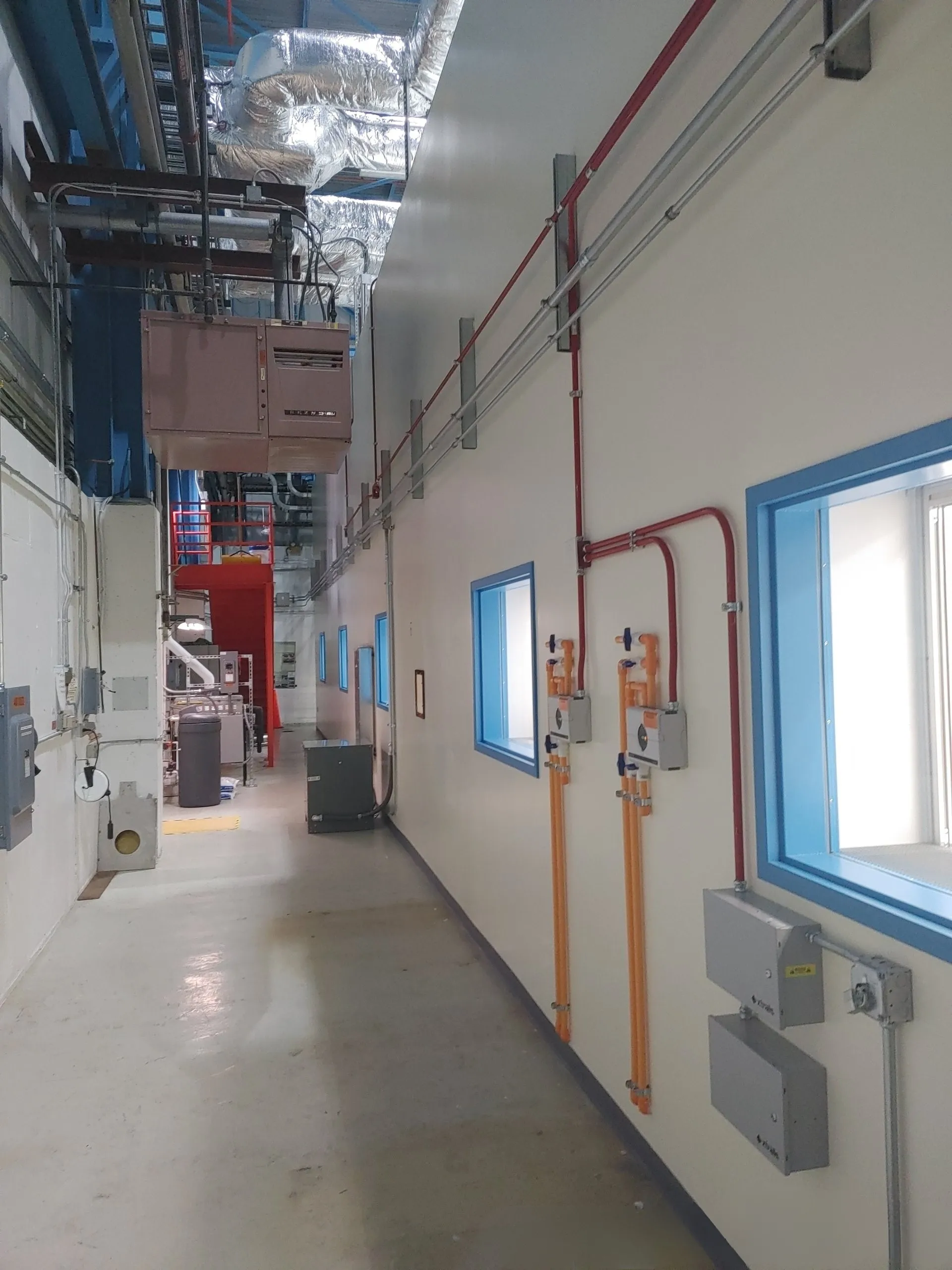 Modular cleanroom hallway with exposed HVAC and utility systems