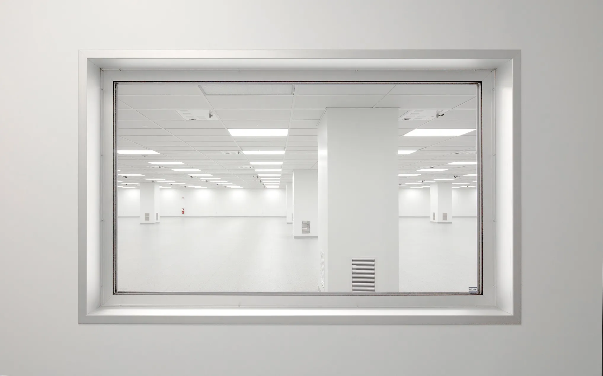 Cleanroom observation window showing sterile controlled environment with HEPA filtration and LED lighting