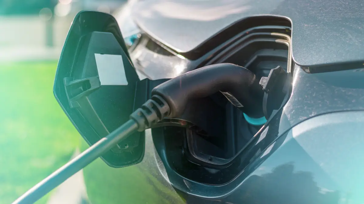 Electric vehicle charging port connected to charger, representing the end-use application of lithium-ion batteries manufactured in controlled dry room environments